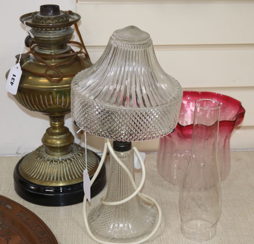 A brass oil lamp with shade and chimney, height 38cm and a glass table lamp